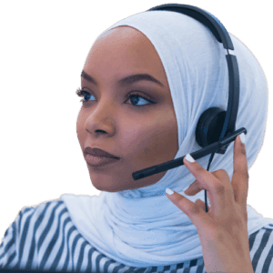 A person wearing a white headscarf and a black and white striped shirt is using a headset with a microphone. They are looking to the side and appear to be engaged in a conversation. The background is a plain, neutral color.