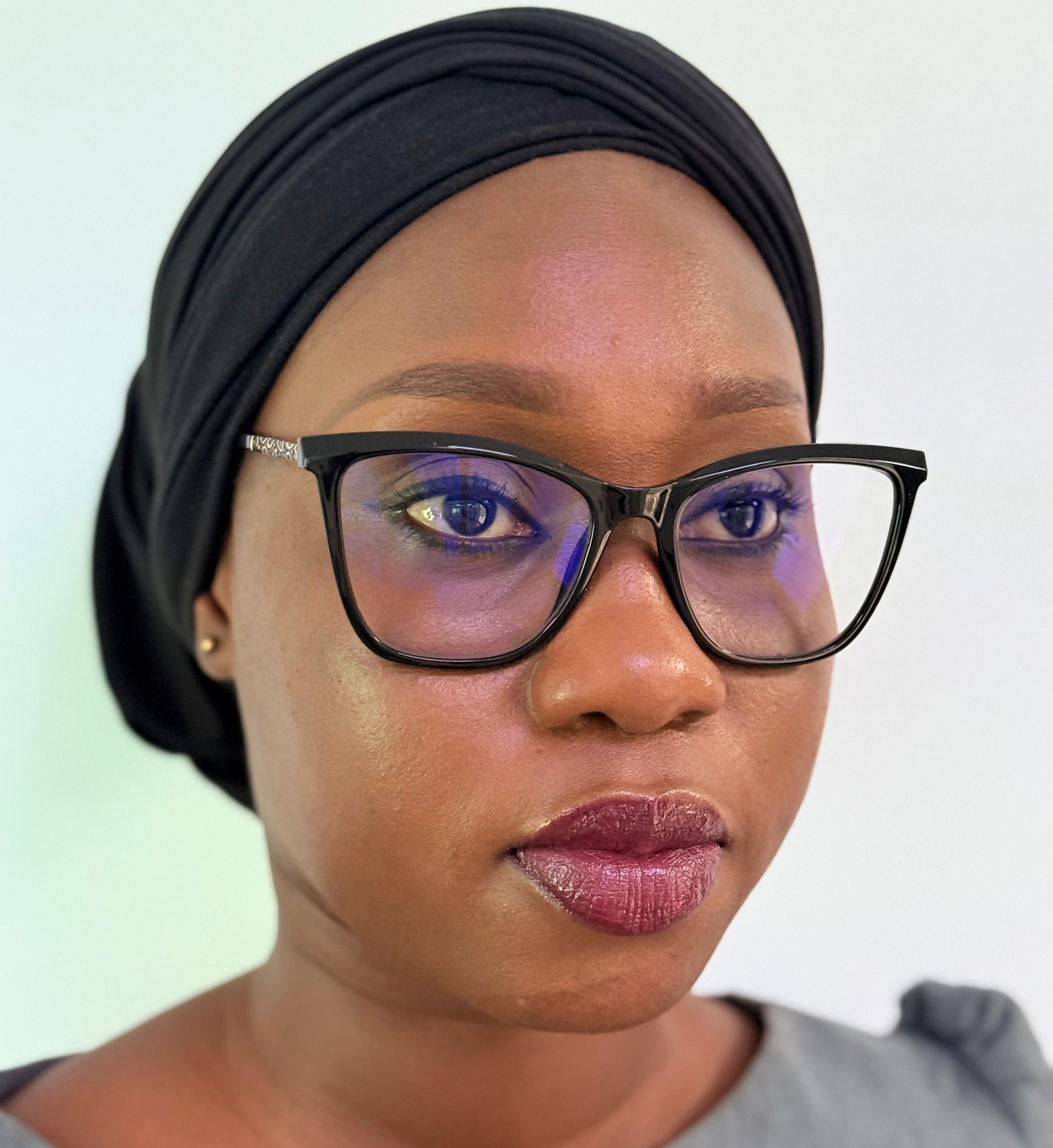 A stylized graphic of a green tree with four horizontal layers of leaves and a brown trunk, resembling a palm tree. The trunk is centrally aligned, and there is a green crescent shape at the bottom. A small green crescent sits at the top of the tree.